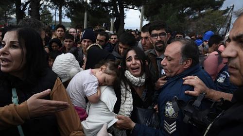 Uma mulher chora enquanto refugiados brigam com a polícia grega em seu esforço para chegar à fronteira com a Macedônia, perto da aldeia grega de Idomeni, domingo, 22 de novembro de 2015. (AP)