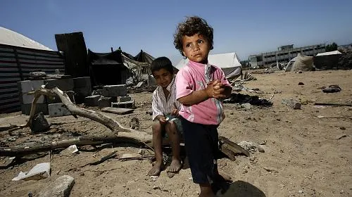As crianças ficam do lado de fora da casa de sua família, que foi destruída durante o recente conflito de quinta-feira, 17 de julho de 2009, na Faixa de Gaza. (Warrick Page / Getty Images for Care International)