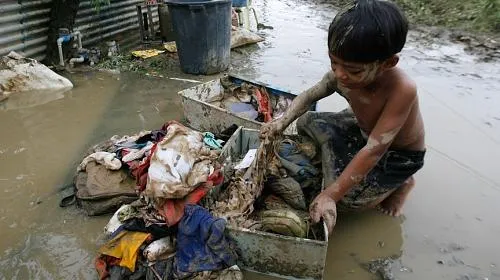 A survivor of Typhoon Ketsana sorts his family's soiled clothes in the Silangan village in suburban Quezon city, north of Manila on September 28, 2009. (Reuters/Erik de Castro, courtesy 