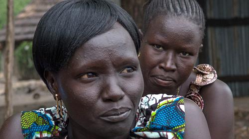 Mulheres participam de uma reunião convocada pela CARE para discutir questões de saneamento em Nimule, Sudão do Sul, uma cidade na fronteira com Uganda que acolhe dezenas de milhares de pessoas deslocadas pela violência em outras partes do país. 28 de março de 2014. Foto de D