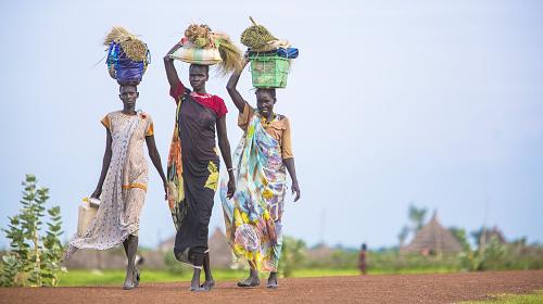 Women carry supplies on top of their heads on a road in Pariang state, northern South Sudan.