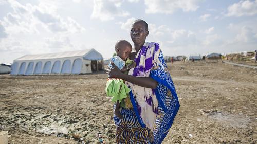 A mother holds her son outside the CARE Nutrition Center in South Sudan.
