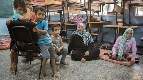 Naimah Abu Halima (56) sits with her daughter Hannah (32) in a UN school after fleeing from the north of Gaza following a warning from the Israeli Defence Forces (IDF).