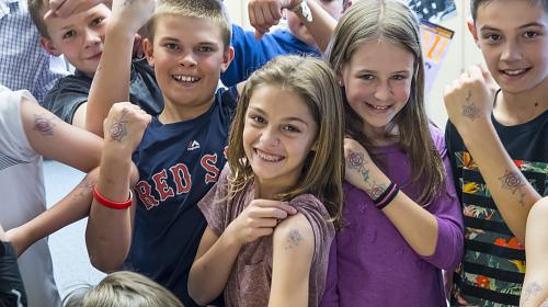 Boulder students show off their temporary tattoos created from the flowers that Safiyo, an 11-year-old Somalian refugee drew. Carey Wagner/CARE