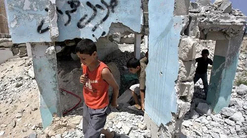 Palestinian children play over the rubble of destroyed houses. CREDIT: Khalil Khokho/CARE