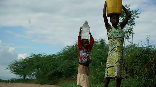 Children in Nsanje district, southern Malawi carry water on their heads. Many are having to travel much further distances to fetch water as the area has been affected by prolonged and ongoing dry spells. CARE/Lucy Beck