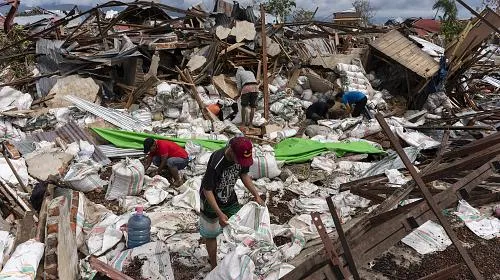 Os trabalhadores coletam cacau em um depósito na vila de Petobo, afetada pela liquefação após o terremoto em 28 de setembro de 2018.