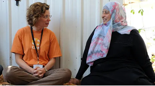 Credit: CARE USA. CEO Michelle Nunn talks with a community representative in Asraq Refugee Camp in Jordan.