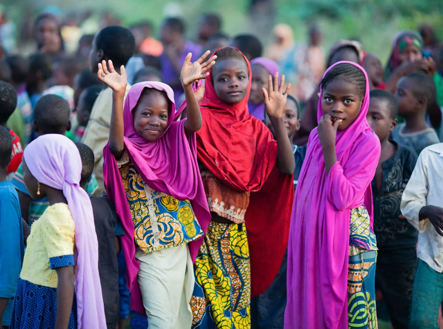 Un groupe d'enfants se réunit dans la région du Sahel au Niger. Trois d'entre eux sourient et saluent la caméra.