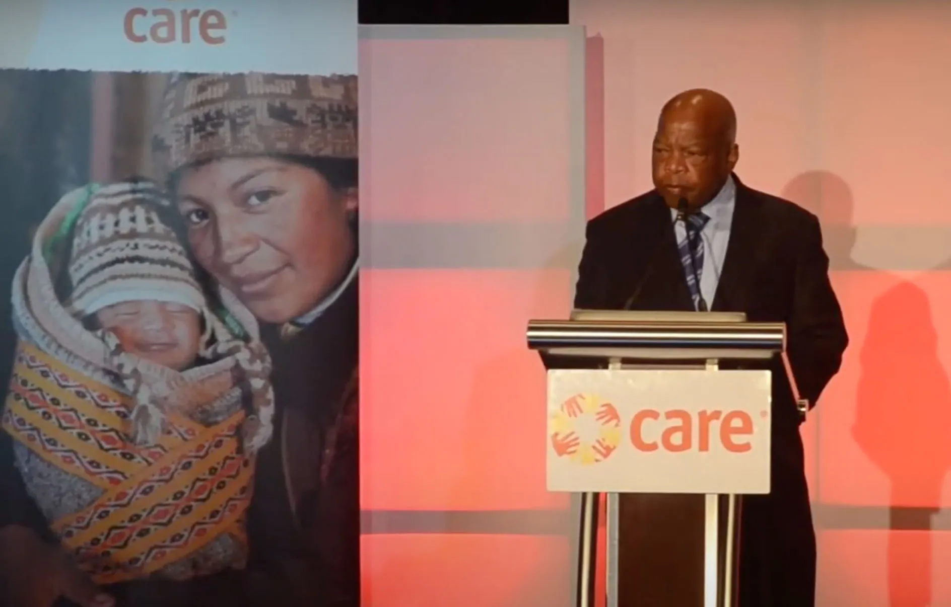 Congressman John Lewis stands a podium on stage at the 2015 CARE National Conference.
