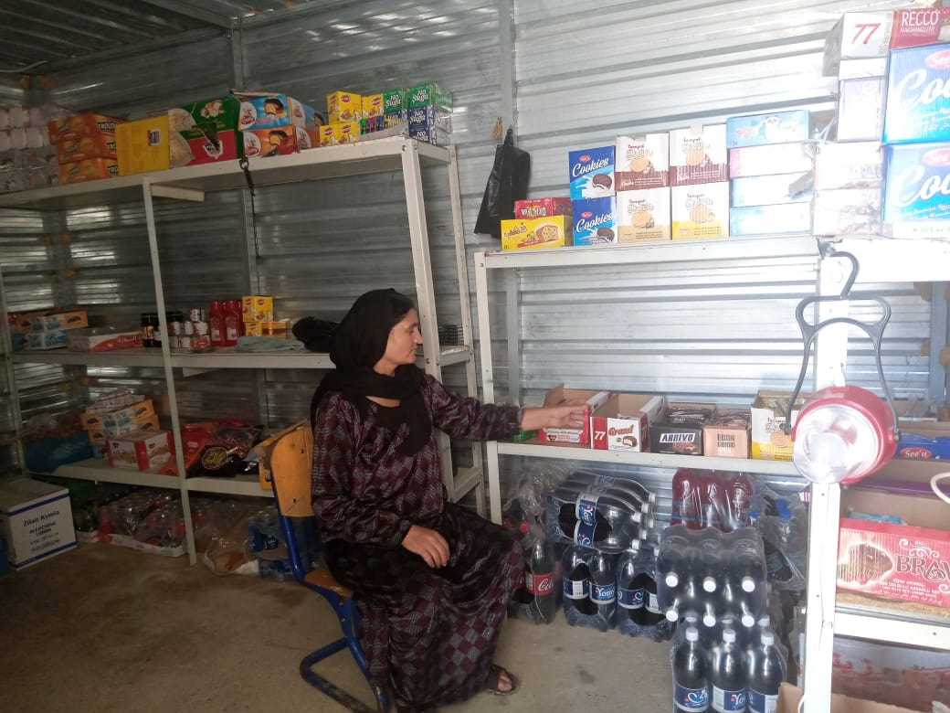 Khonaf Saido Abdullah, 54, living in Rwanga camp, Northern Iraq sits in her shop made of metal siding and an exposed concrete foundation with many unsold items she still has in stock after her shop was forced to close due to the COVID-19 pandemic.