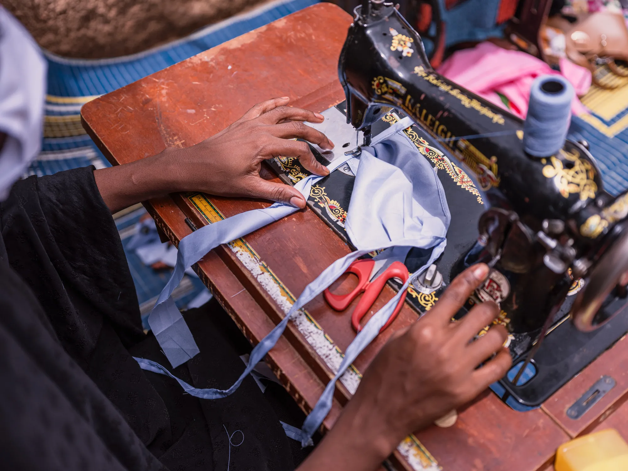 Una mujer de Níger usa una máquina de coser para hacer una máscara.