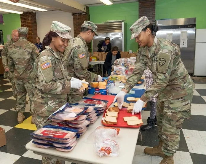 Members of the Army National Guard and other volunteers prepare bags of food for residents of New Rochelle, New York, where a one-mile radius containment area was set up to halt the spread of coronavirus. (Shutterstock)