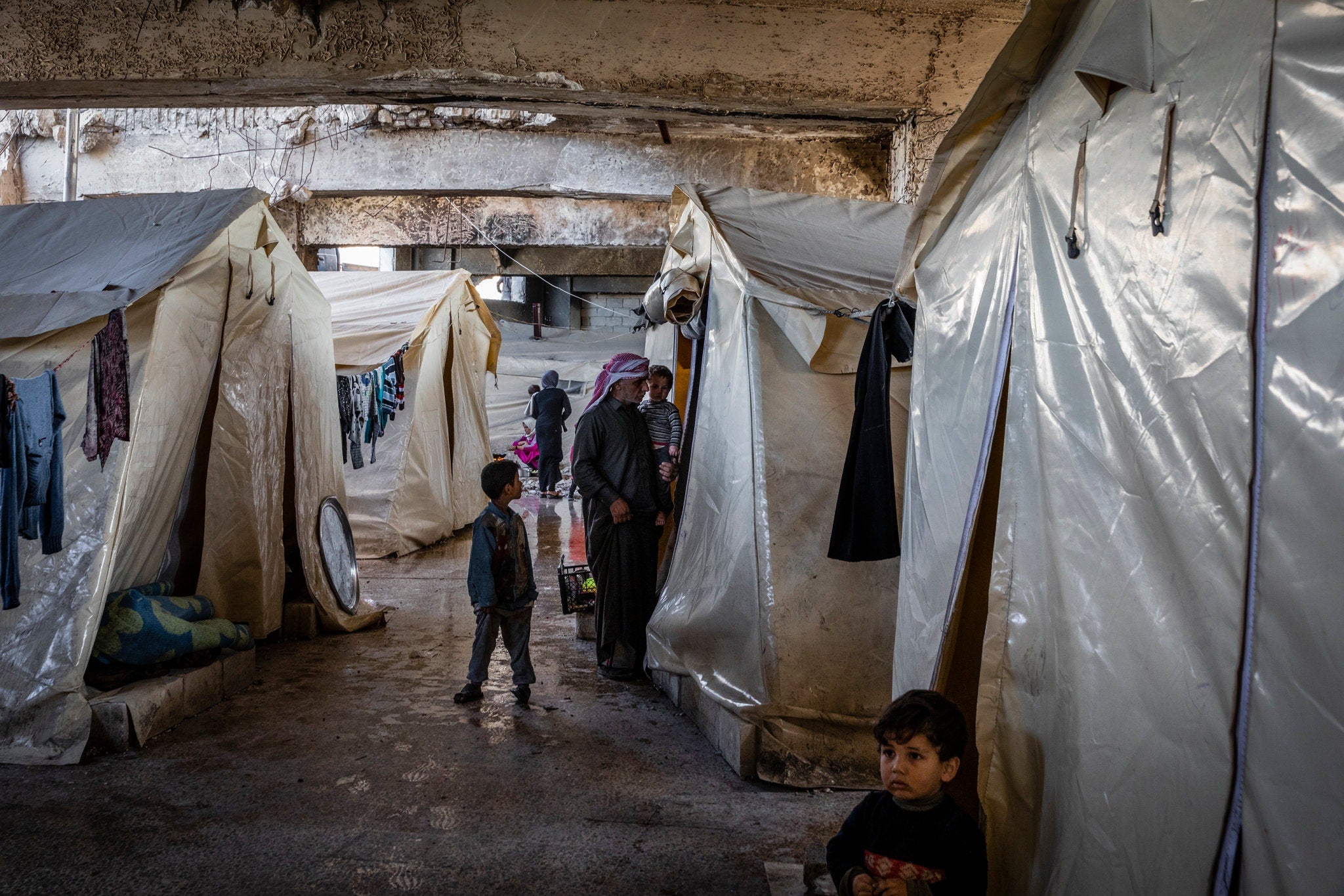 Syrian families, displaced by recent fighting, living in tents underneath a sports stadium in Idlib, Syria.