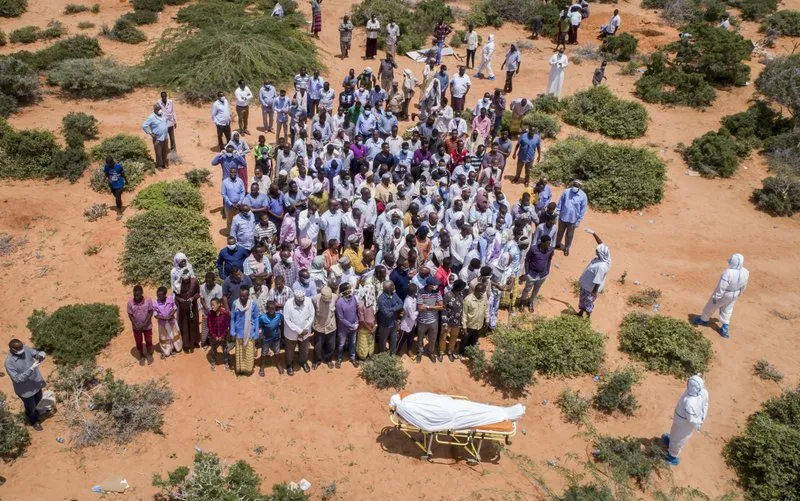 In this April 30, 2020, file photo, mourners gather to bury an elderly man believed to have died of the coronavirus but whose family asked not to be named because of the social stigma, in Mogadishu, Somalia. A dangerous stigma has sprung up around the coronavirus in Africa — fueled, in part, by severe quarantine rules in some countries as well as insufficient information about the virus. (AP Photo/File)