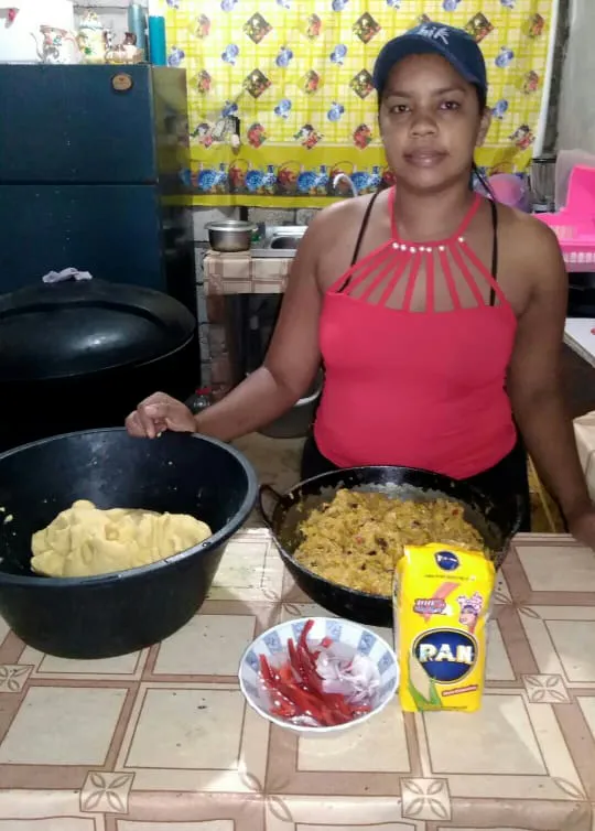 Uma mulher prepara comida em uma cozinha.