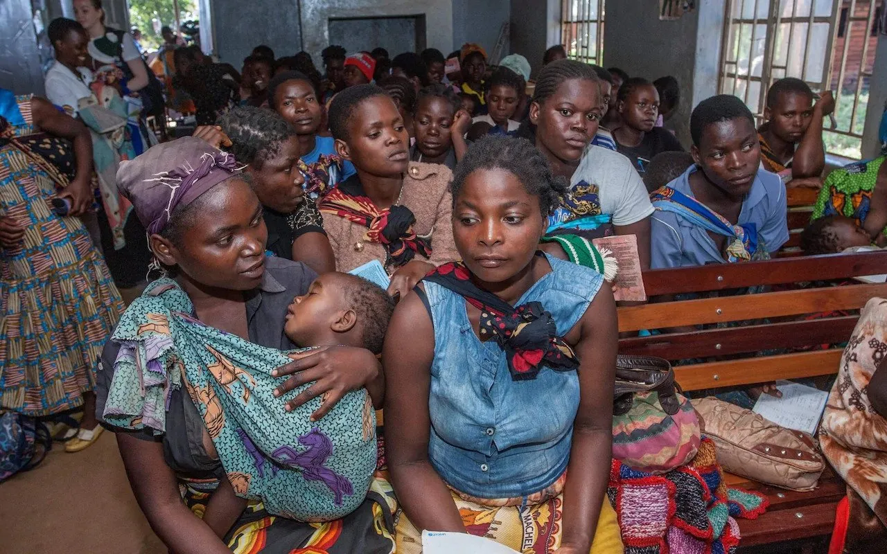 Madres esperando en una clínica con sus bebés en 2019, antes de que la pandemia cerrara muchos servicios similares CRÉDITO: AFP
