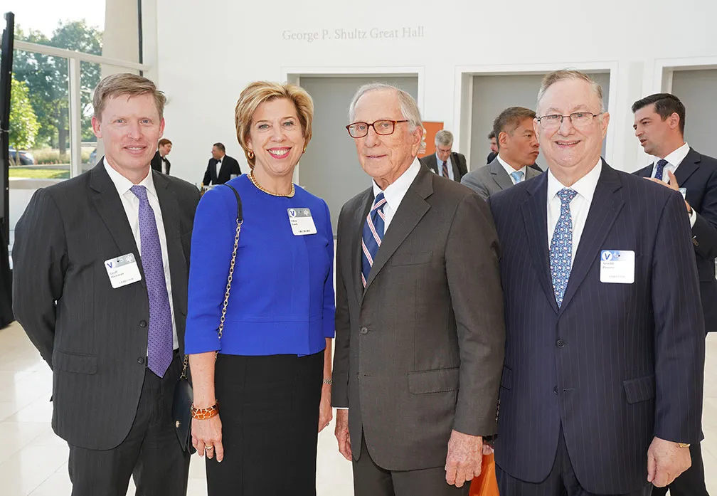 Four attendees - three men and one woman - pose for the camera at the Global Leaders Network Awards Reception.