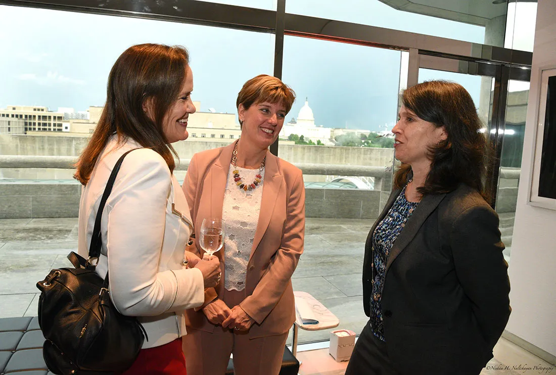 Michéle Flournoy, la ministra Marie-Claude Bibeau y otra mujer conversan.