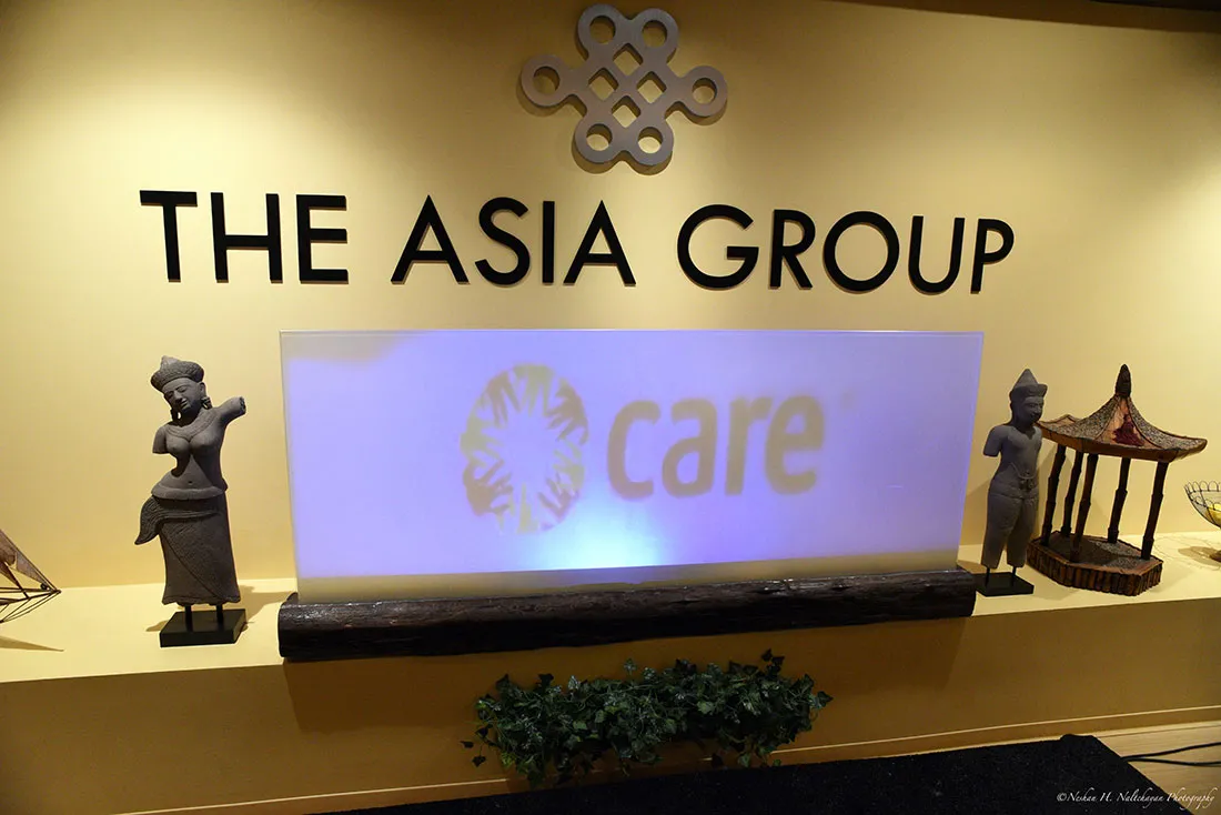 A wall lined with statues shows The Asia Group logo.