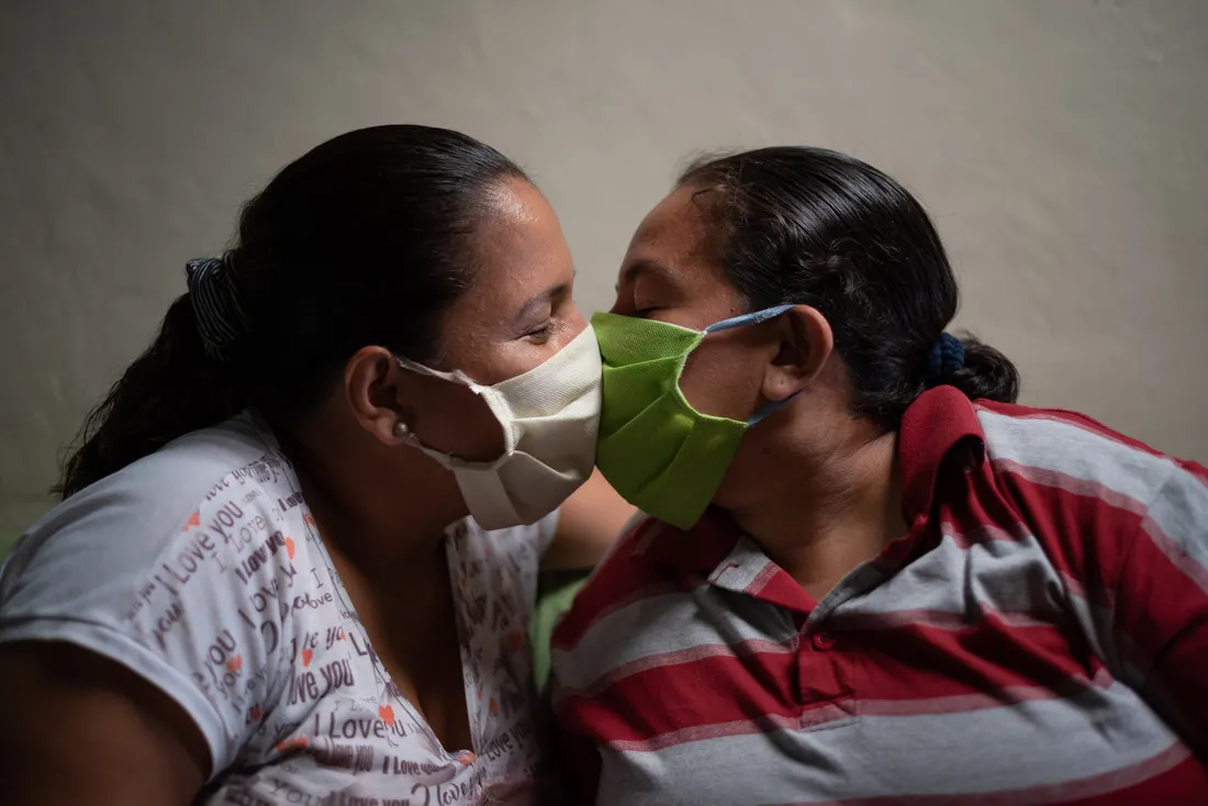Two people kiss with face masks on