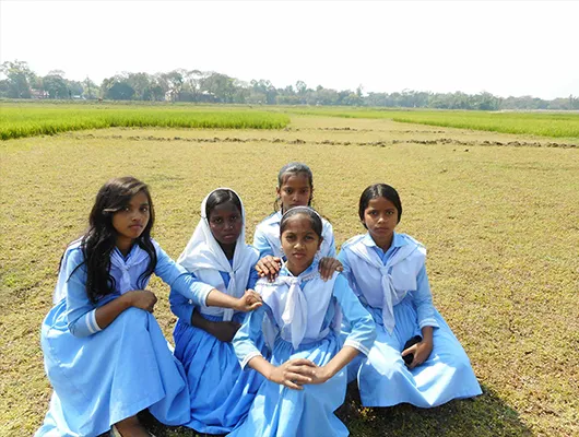 Cinq jeunes filles dans leur uniforme scolaire blanc et bleu.