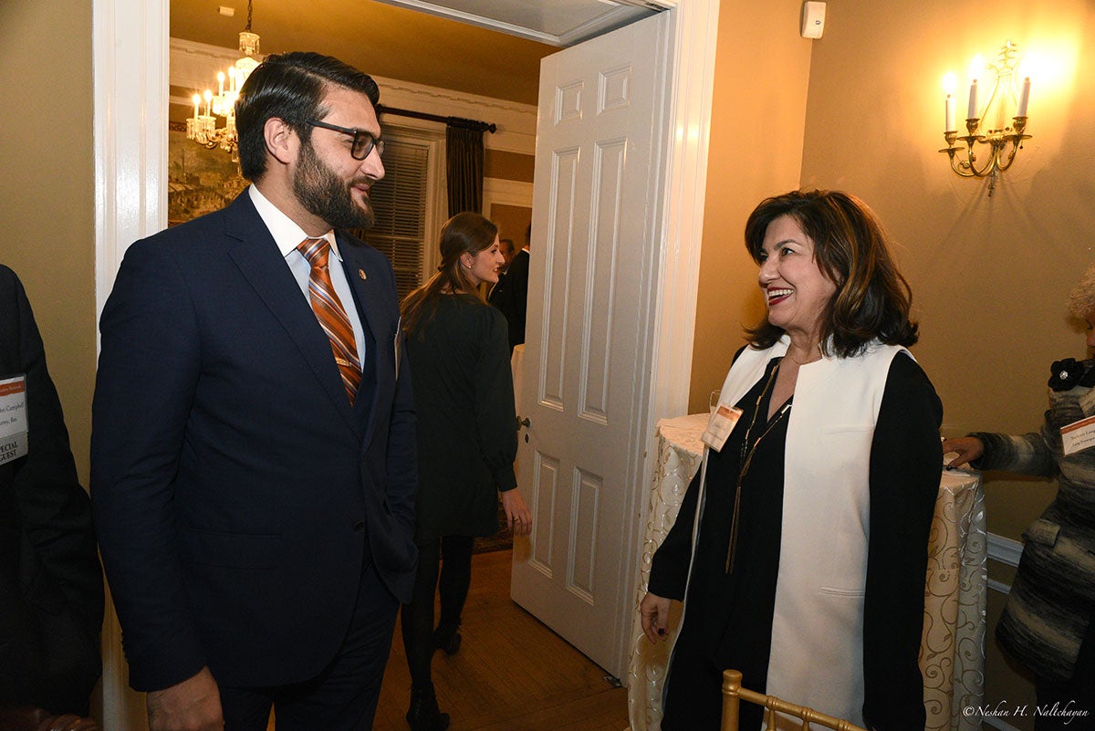 Ambassador Hamdullah Mohib is talking with a woman in a black dress and a white vest