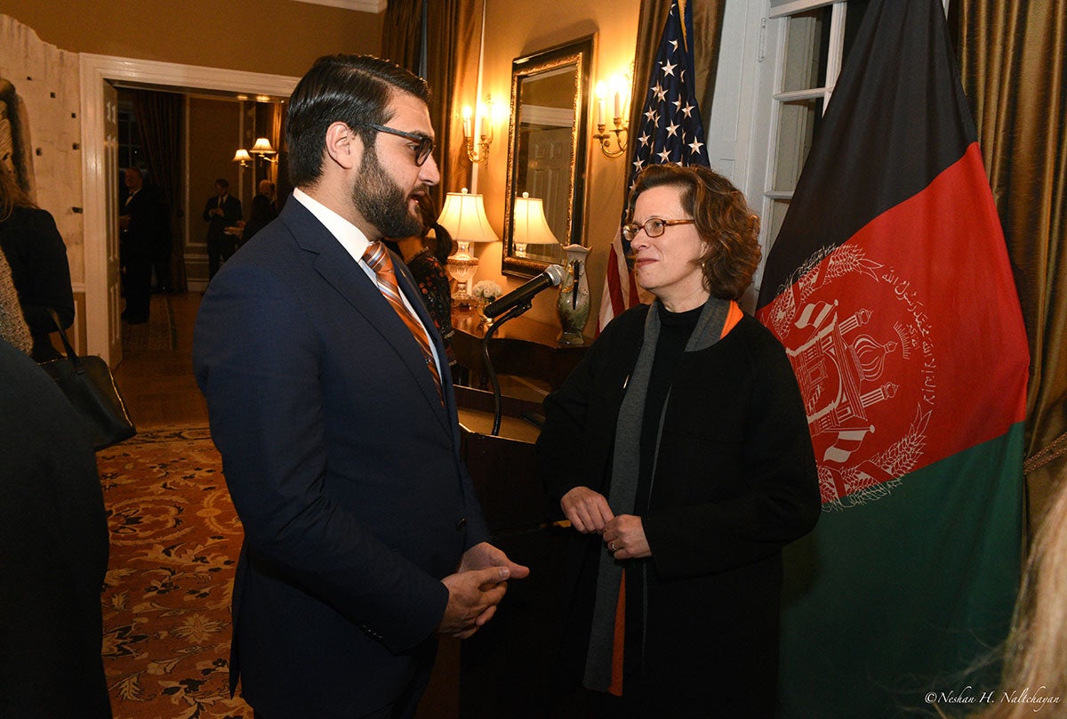 CARE CEO Michelle Nunn and Ambassador Hamdullah Mohib are talking while standing in front of both the American and Afghan flags