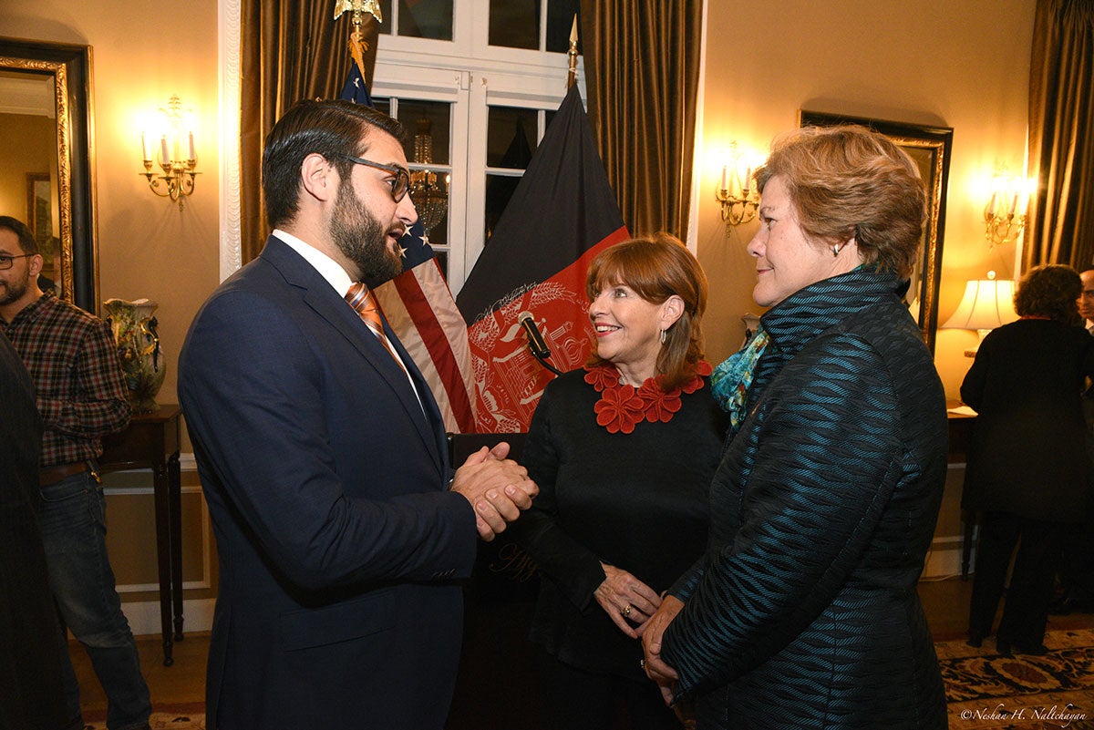 Ambassador Hamdullah Mohib is talking with a woman in a black dress and another one in a dark green suit