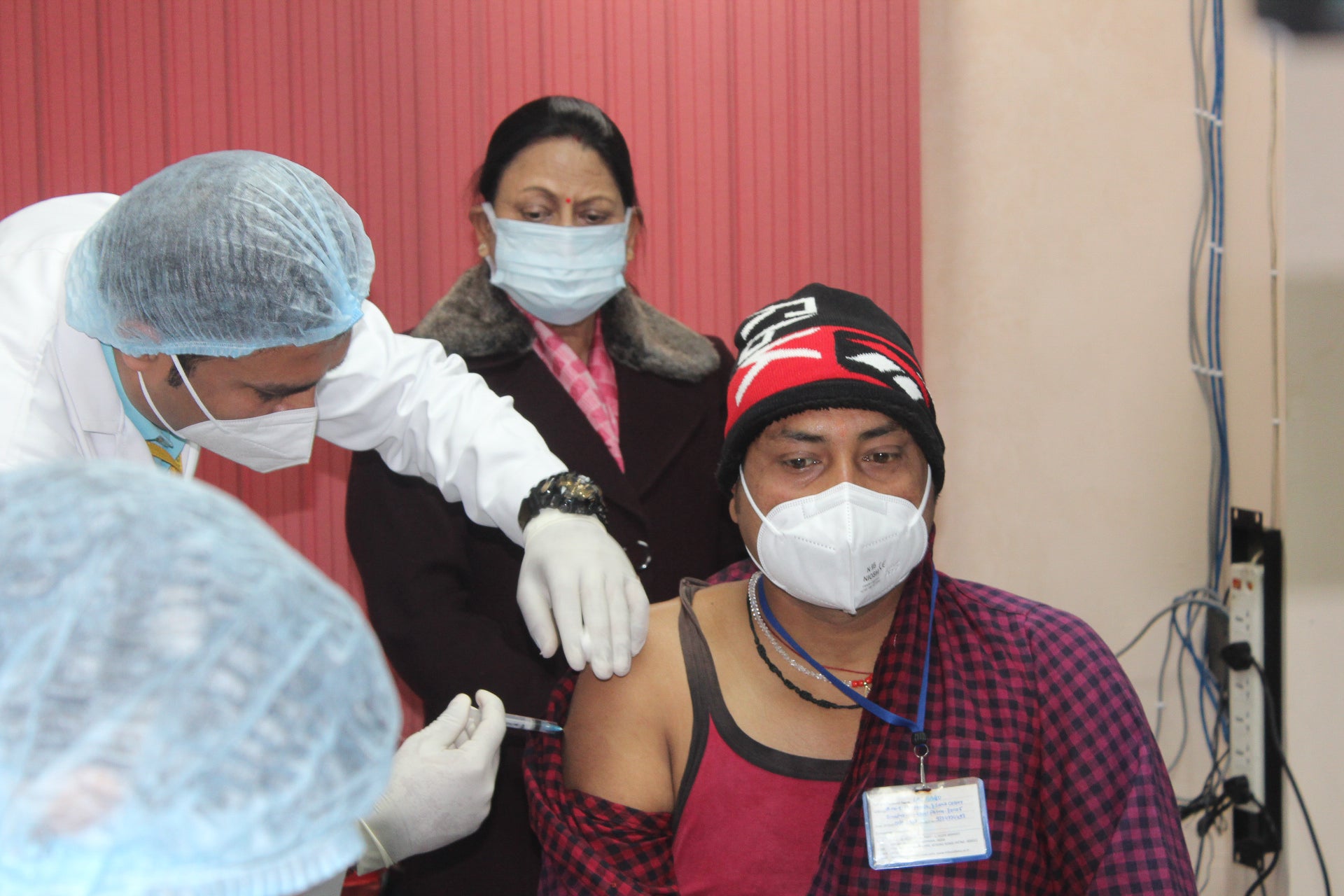 A health care worker administers a COVID-19 vaccination in India.