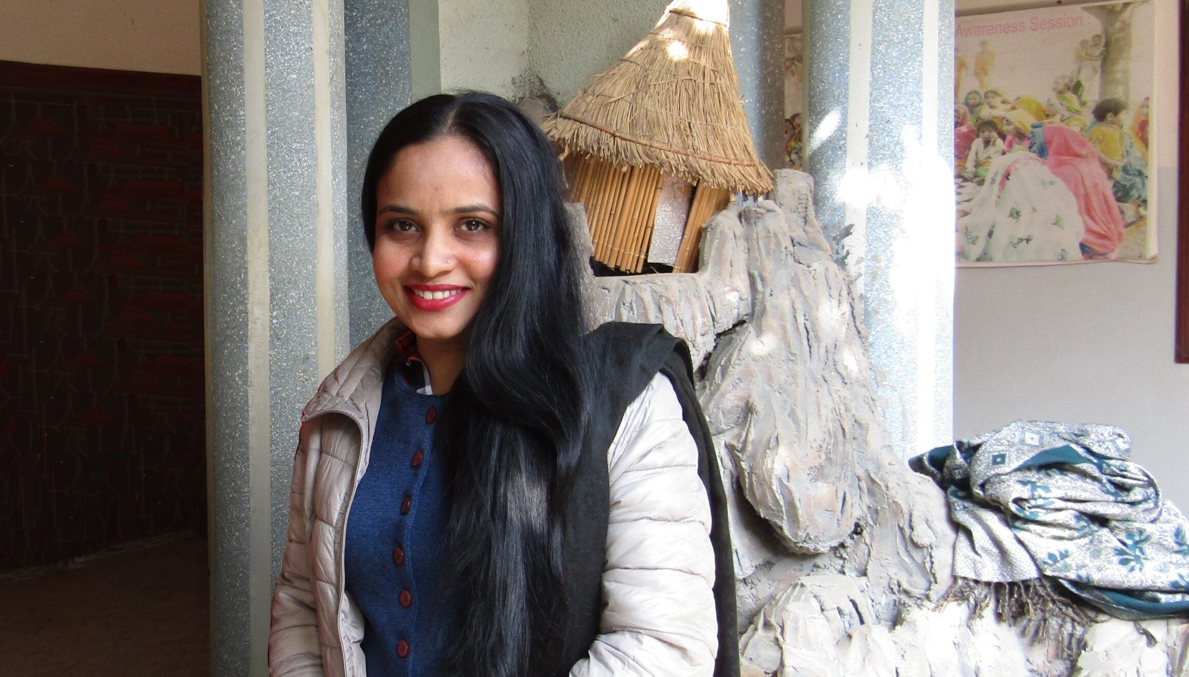 Une femme pakistanaise en blouse blanche sourit pour un portrait