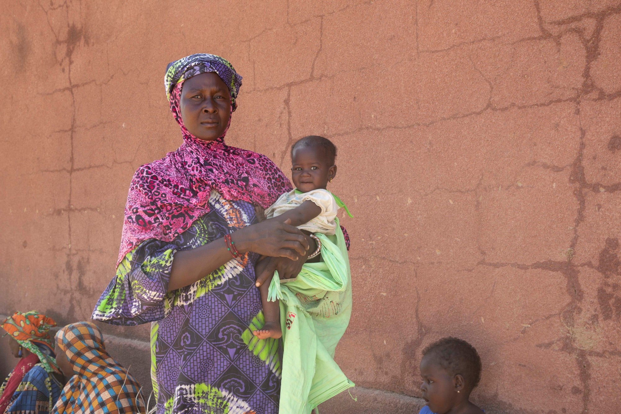 A mother and child stand in a camp for internally displaced persons in Mali.