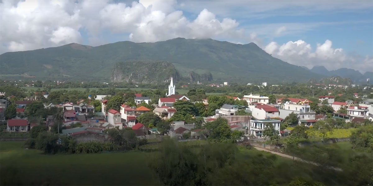 A landscape photo of a town. Behind the town is a mountain range.