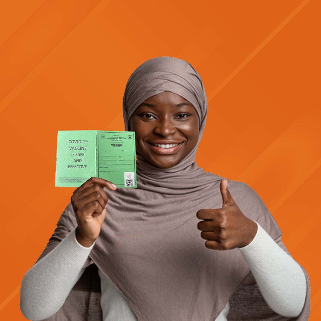 A woman holds up a green card that says, 