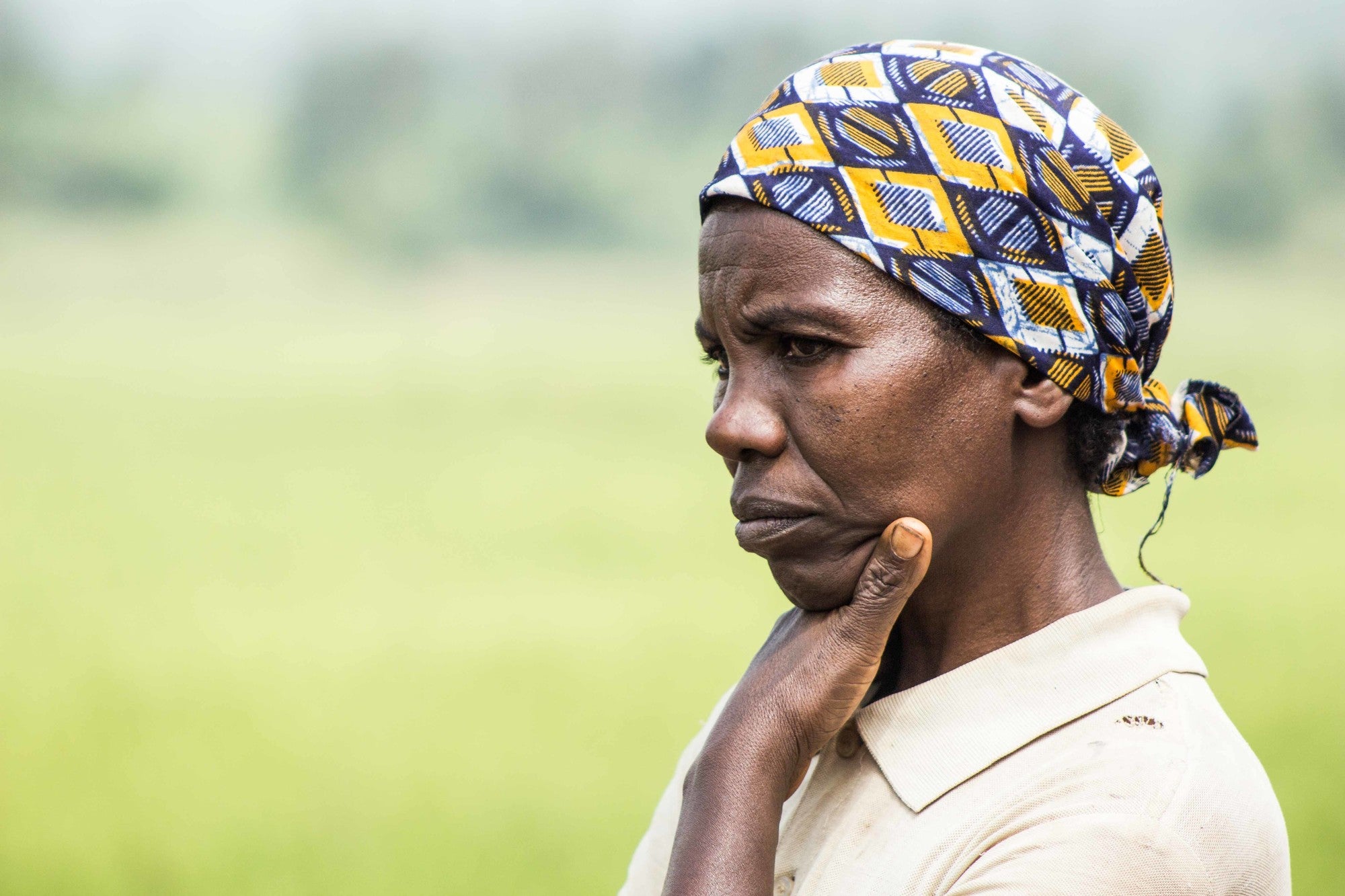 A woman in Burundi stands in a field.