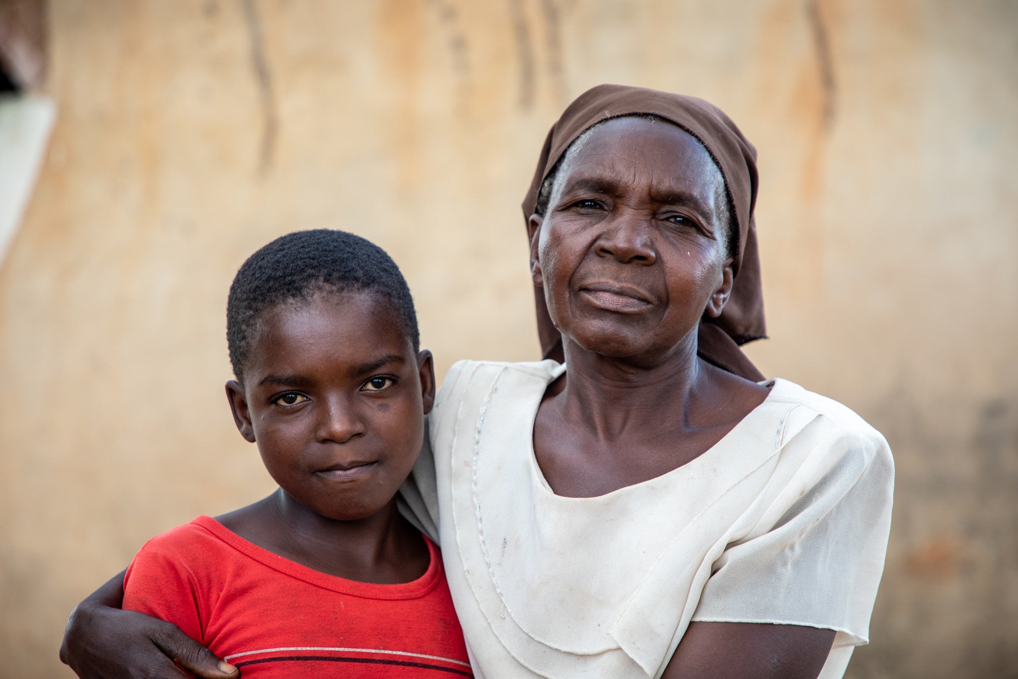Une grand-mère met sa main sur l'épaule de sa petite-fille au Zimbabwe.