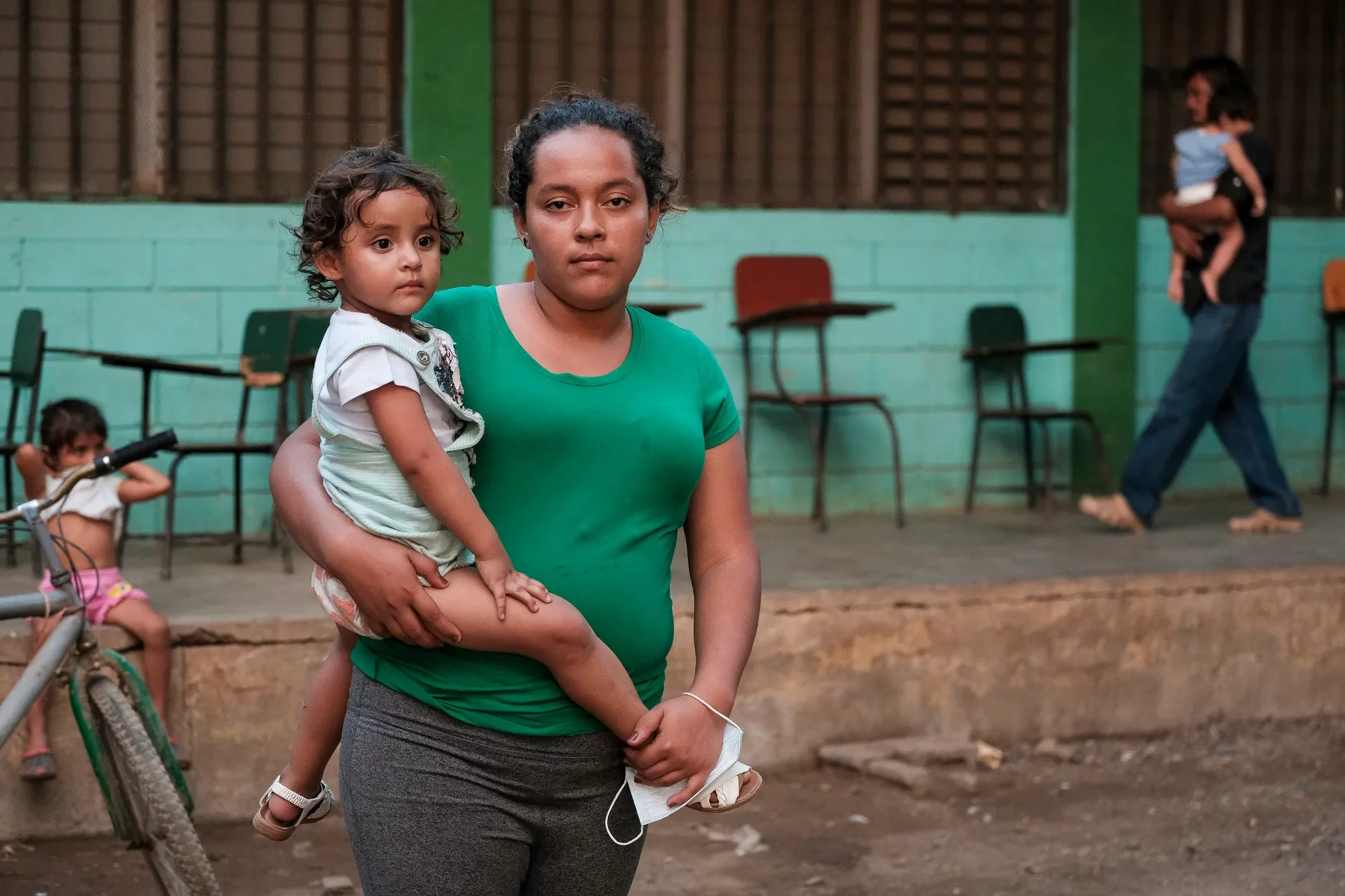 Una madre sostiene a su hija cerca de un albergue en Honduras.