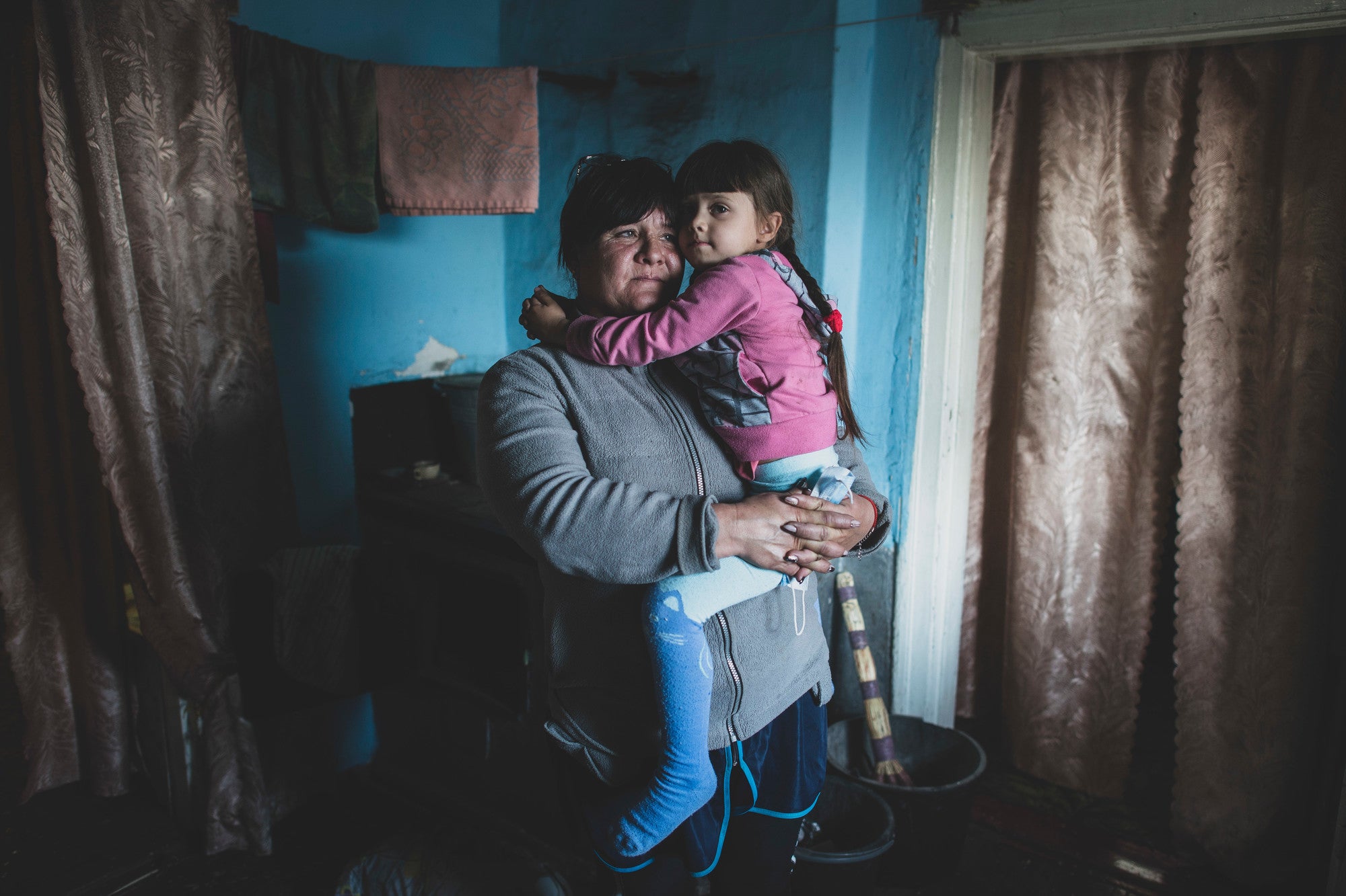 Une mère tient sa fille dans une maison en Ukraine.