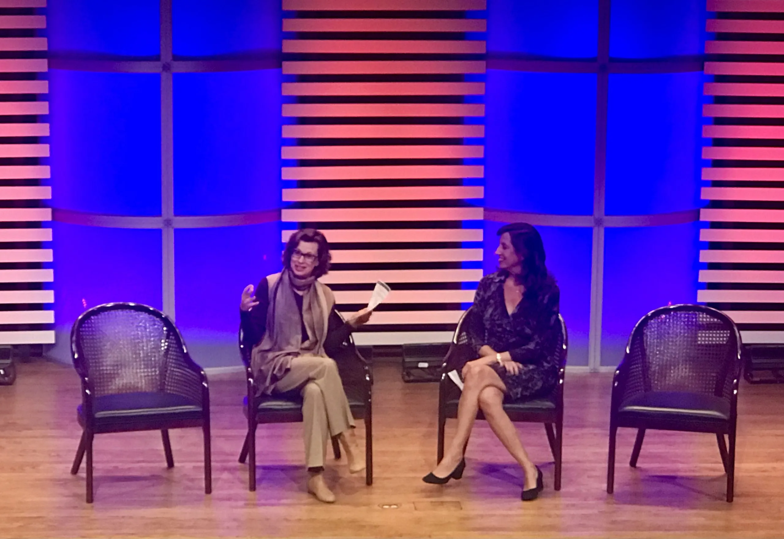 Dos mujeres sentadas en un panel de discusión.
