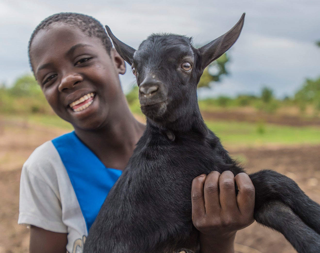 Una niña sostiene una cabra.