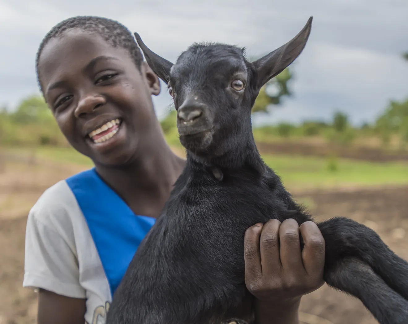 Una niña sostiene una cabra.