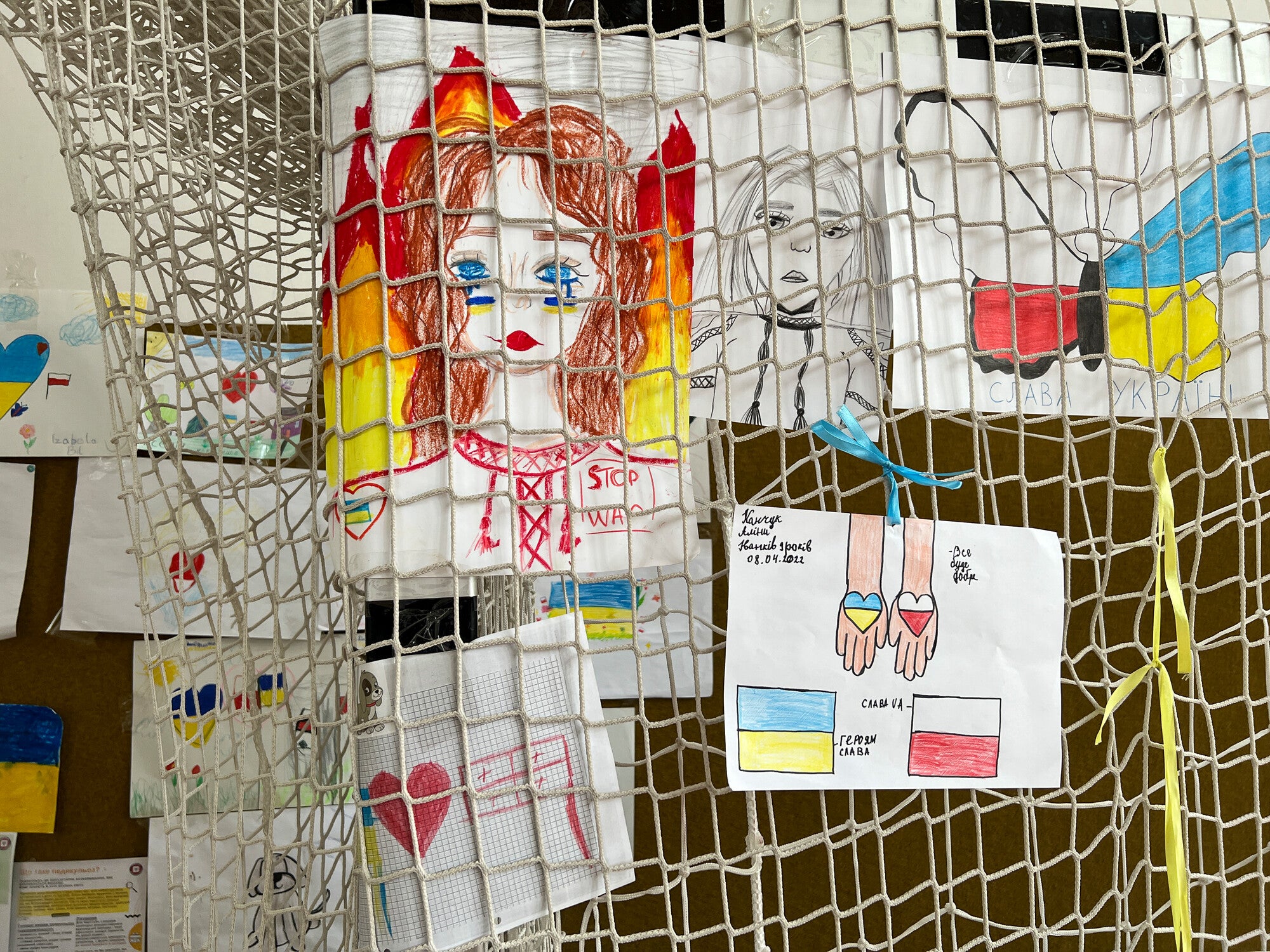 drawings by Ukrainian refugee children that were informally displayed at an arts and crafts station in a converted school gym