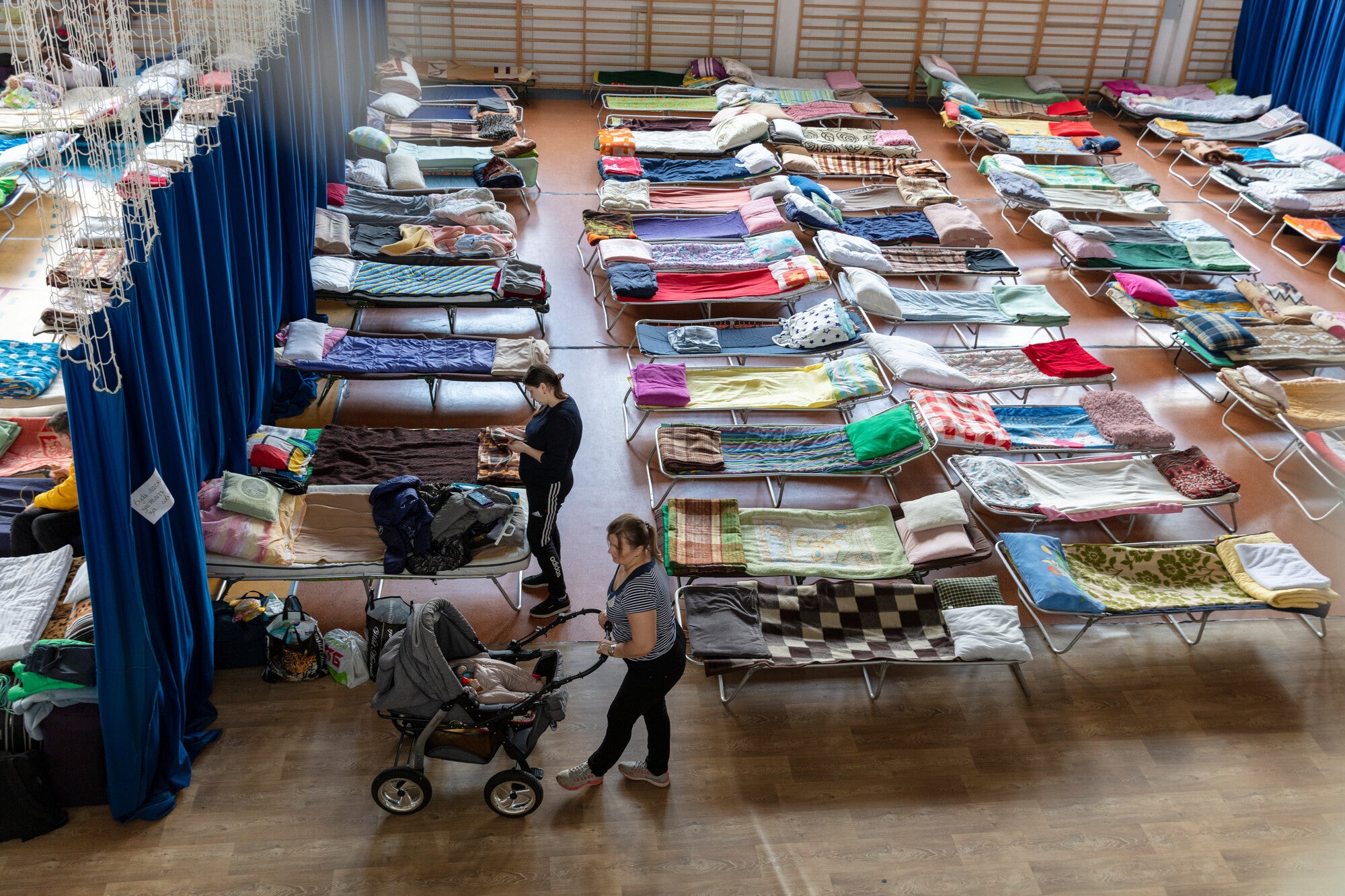 A school gym, Hala Sportowa, Przy Szkole Podstawowej, serves as temporary housing for refugees in the Polish border own, Hrebrenne.