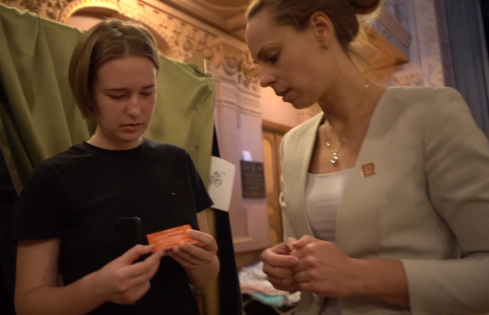 Image of CARE staff member sharing an information card with a refugee woman
