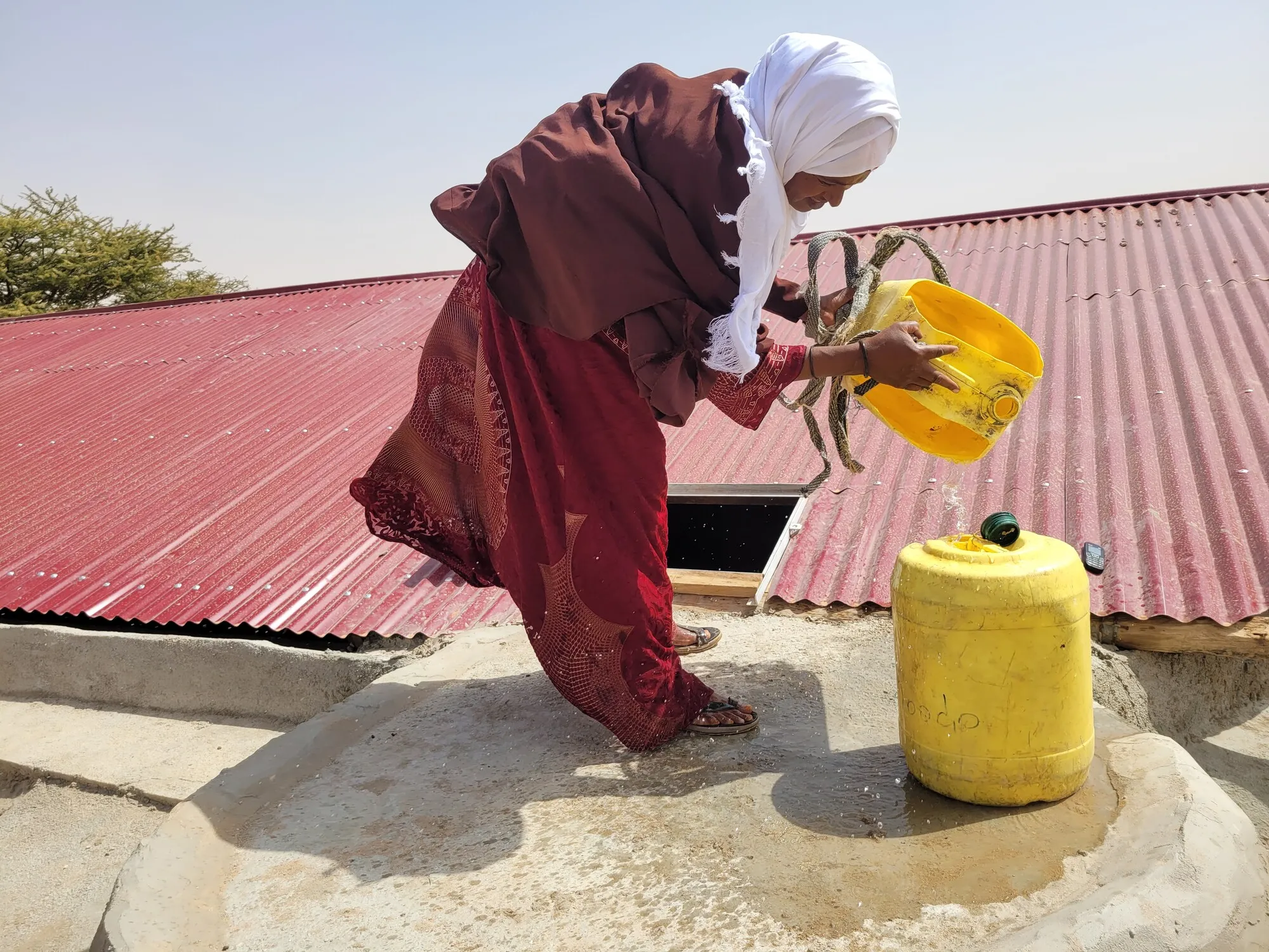 Woman pouring water into a storage tank