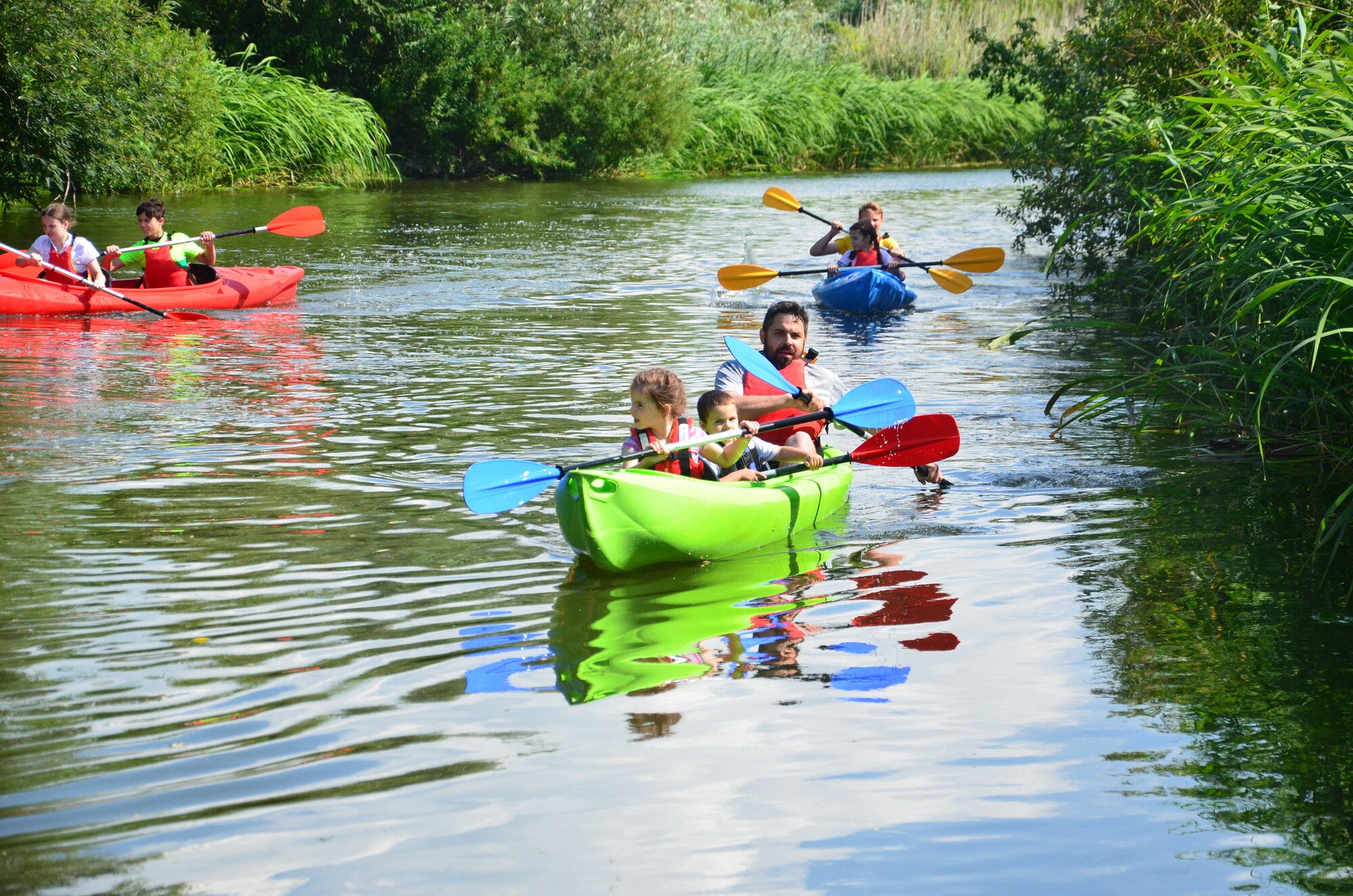 Un grupo de personas en kayaks en un río.
