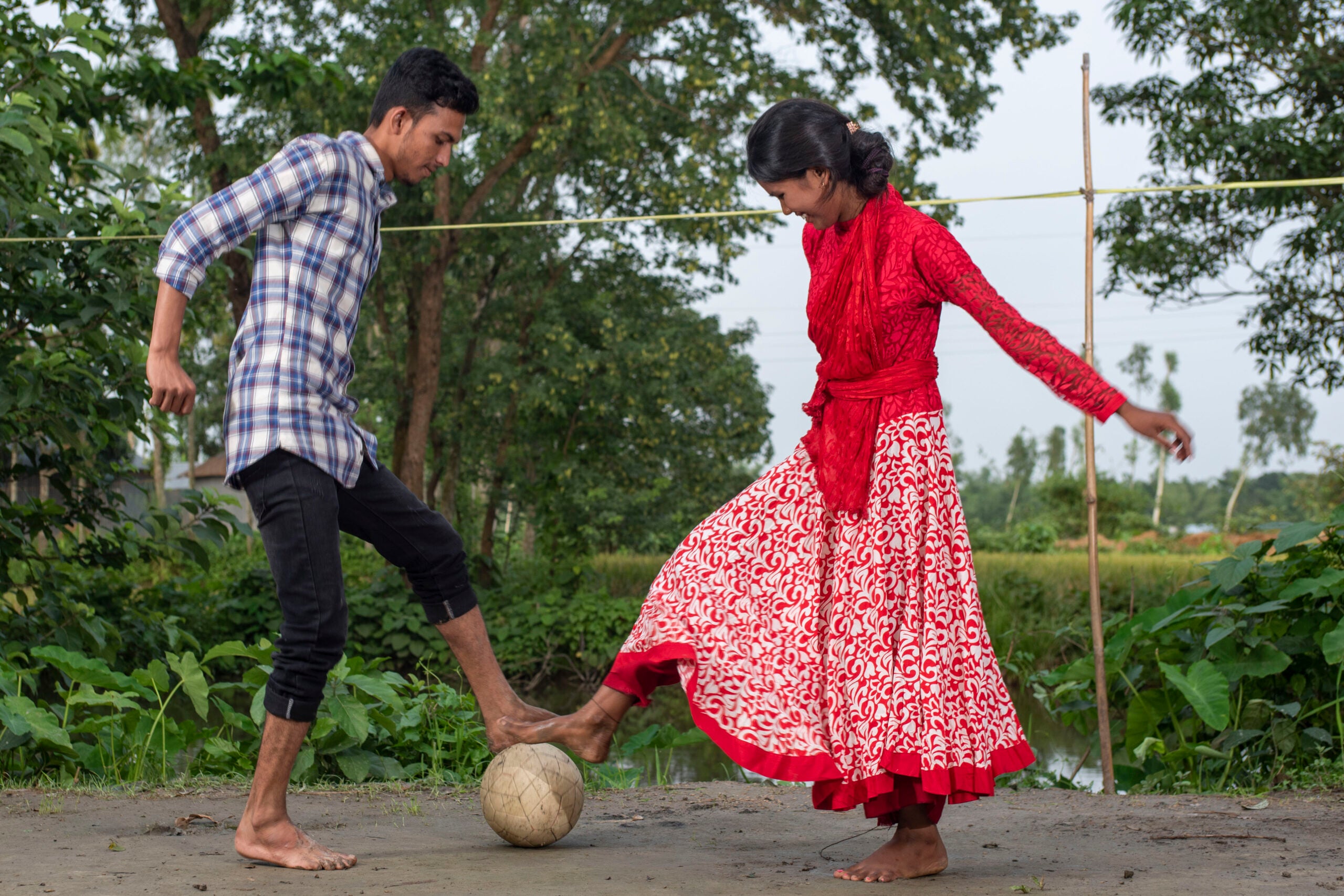 Girl and boy play soccer outside