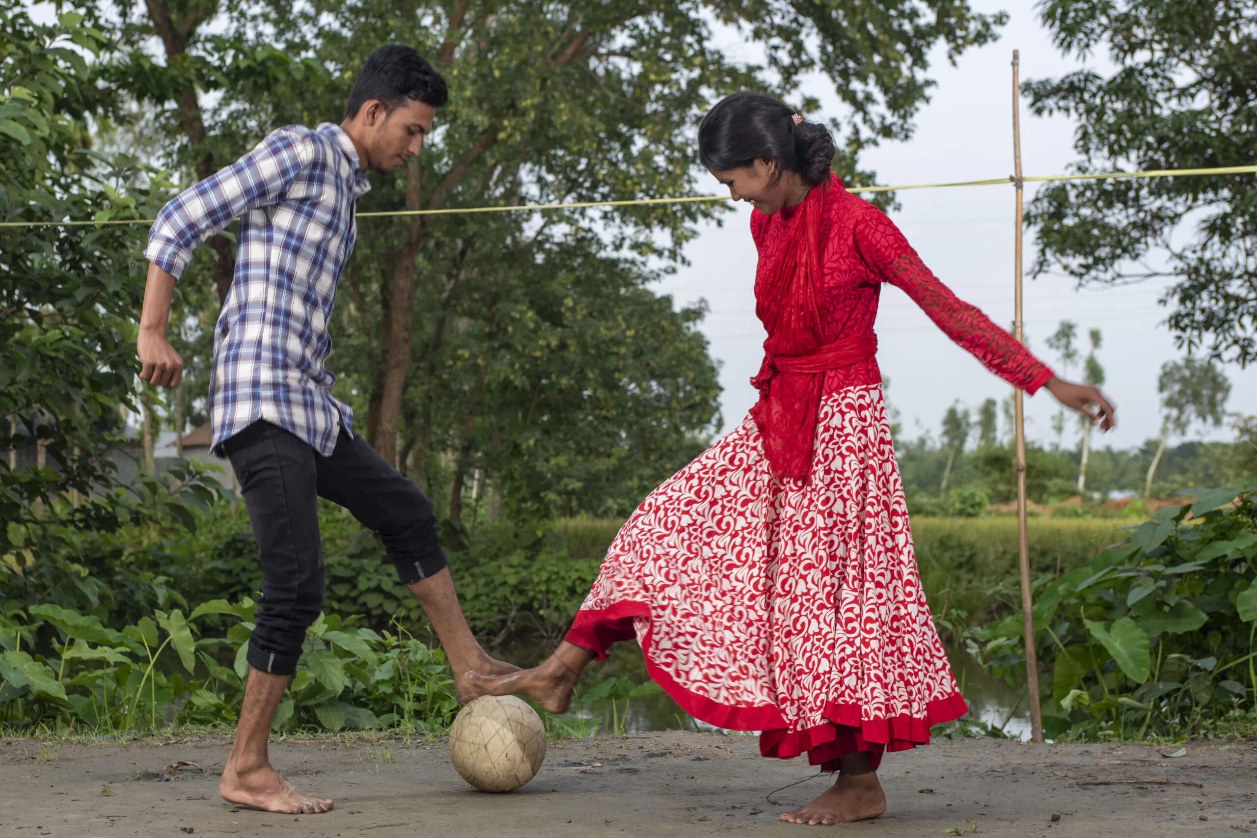 Girl and boy play soccer outside