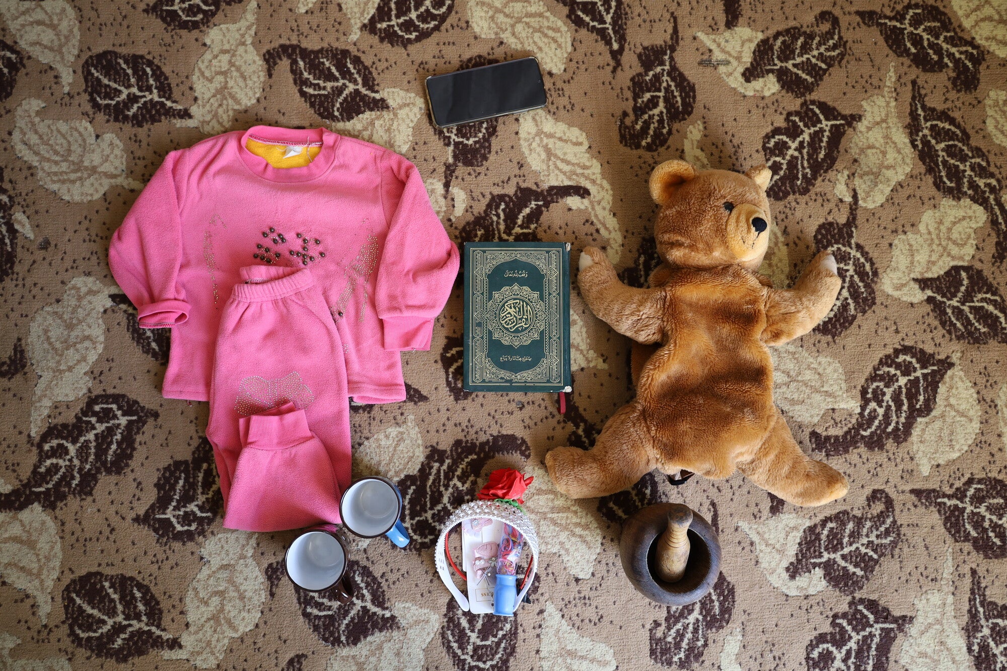 An assortment of children's items, including a stuffed bear and pajamas