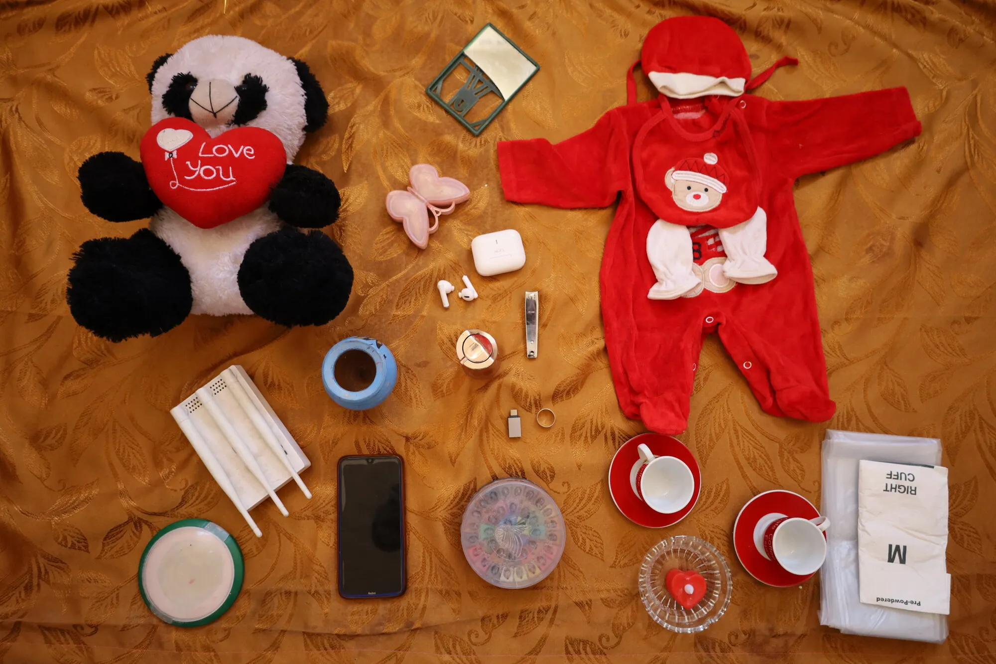 Selection of children's objects, including stuffed panda, baby clothes, and tea set.